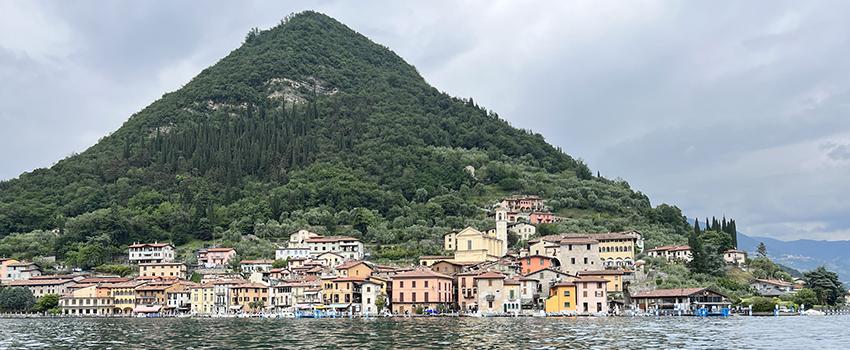 Mountain with houses in front of it and lake in Northern Italy.